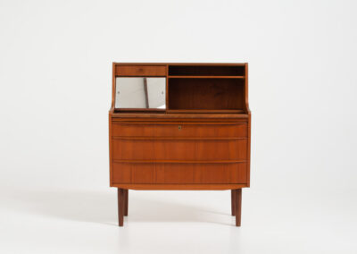 Danish secretary in teak, 1960s. A compact and multi functional piece that contains three main drawers, a small drawer on top, a mirror that flips out and a convenient pull-out leaf. In very good condition. Original key included.