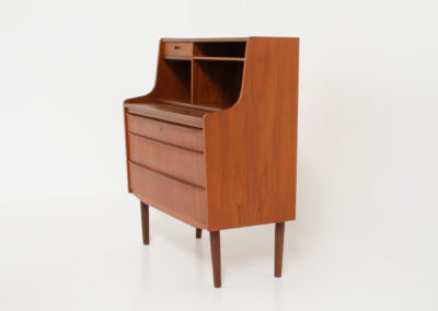 Danish secretary in teak, 1960s. A compact and multi functional piece that contains three main drawers, a small drawer on top, a mirror that flips out and a convenient pull-out leaf. In very good condition. Original key included.