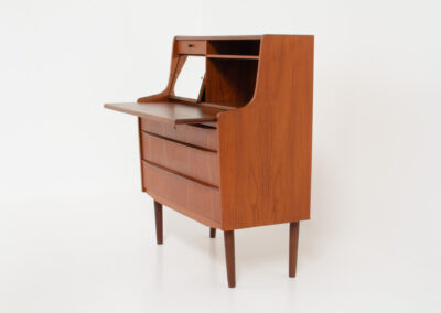 Danish secretary in teak, 1960s. A compact and multi functional piece that contains three main drawers, a small drawer on top, a mirror that flips out and a convenient pull-out leaf. In very good condition. Original key included.