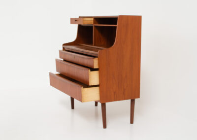 Danish secretary in teak, 1960s. A compact and multi functional piece that contains three main drawers, a small drawer on top, a mirror that flips out and a convenient pull-out leaf. In very good condition. Original key included.