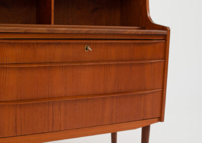 Danish secretary in teak, 1960s. A compact and multi functional piece that contains three main drawers, a small drawer on top, a mirror that flips out and a convenient pull-out leaf. In very good condition. Original key included.