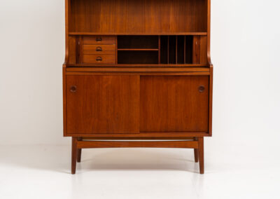 Teak bookcase/desk by Johannes Sorth for Borholms Møbelfabrik (Denmark, 1960s). A well-known and super multi functional design with a high quality standard. Featuring two sliding doors with lots of storage space inside, a convenient pull-out leaf, super detailed tambour doors with some storage space and drawers inside and two adjustable shelves. In very good condition with one repair spot on the right corner. Tambour doors open very smoothly. Marked by maker.