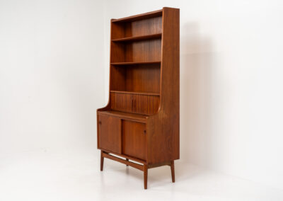 Teak bookcase/desk by Johannes Sorth for Borholms Møbelfabrik (Denmark, 1960s). A well-known and super multi functional design with a high quality standard. Featuring two sliding doors with lots of storage space inside, a convenient pull-out leaf, super detailed tambour doors with some storage space and drawers inside and two adjustable shelves. In very good condition with one repair spot on the right corner. Tambour doors open very smoothly. Marked by maker.