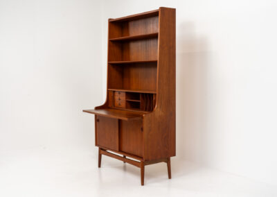 Teak bookcase/desk by Johannes Sorth for Borholms Møbelfabrik (Denmark, 1960s). A well-known and super multi functional design with a high quality standard. Featuring two sliding doors with lots of storage space inside, a convenient pull-out leaf, super detailed tambour doors with some storage space and drawers inside and two adjustable shelves. In very good condition with one repair spot on the right corner. Tambour doors open very smoothly. Marked by maker.