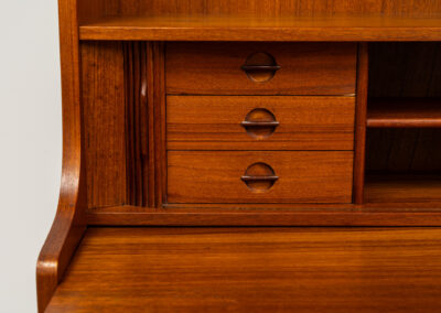 Teak bookcase/desk by Johannes Sorth for Borholms Møbelfabrik (Denmark, 1960s). A well-known and super multi functional design with a high quality standard. Featuring two sliding doors with lots of storage space inside, a convenient pull-out leaf, super detailed tambour doors with some storage space and drawers inside and two adjustable shelves. In very good condition with one repair spot on the right corner. Tambour doors open very smoothly. Marked by maker.