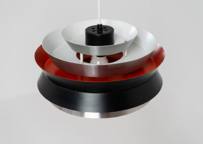 Trava pendant light by Carl Thore for Granhaga (Sweden, 1960s). A sleek design featuring six aluminium shades. Two of them are lacquered in black in the outside and lacquered in orange on the inside. The orange interior creates a beautiful defused and moody light dispersion. Newly rewired, in very good condition.