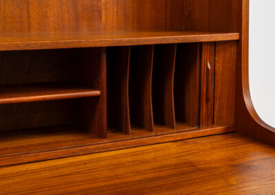 Teak bookcase/desk by Johannes Sorth for Borholms Møbelfabrik (Denmark, 1960s). A well-known and super multi functional design with a high quality standard. Featuring two sliding doors with lots of storage space inside, a convenient pull-out leaf, super detailed tambour doors with some storage space and drawers inside and two adjustable shelves. In very good condition with one repair spot on the right corner. Tambour doors open very smoothly. Marked by maker.