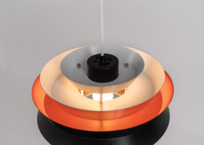 Trava pendant light by Carl Thore for Granhaga (Sweden, 1960s). A sleek design featuring six aluminium shades. Two of them are lacquered in black in the outside and lacquered in orange on the inside. The orange interior creates a beautiful defused and moody light dispersion. Newly rewired, in very good condition.
