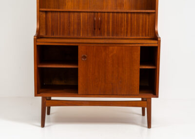 Teak bookcase/desk by Johannes Sorth for Borholms Møbelfabrik (Denmark, 1960s). A well-known and super multi functional design with a high quality standard. Featuring two sliding doors with lots of storage space inside, a convenient pull-out leaf, super detailed tambour doors with some storage space and drawers inside and two adjustable shelves. In very good condition with one repair spot on the right corner. Tambour doors open very smoothly. Marked by maker.