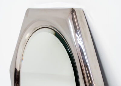 Space Age hexagon wall mirror (Italy, 1970s). A stunning piece made out of polished metal with a round inlay mirror and a beveled edge. It looks like one solid shiny piece and is a real eye catcher in the room. The mirror has several mounting points so that it can be hung in two different ways. In perfect condition.