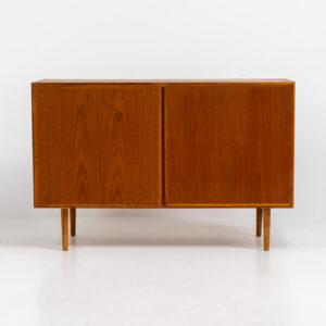 Midcentury Danish cabinet by Omann Jun (Denmark, 1960s). A sleek and convenient design with handle free doors and adjustable shelves on the inside. It’s made out of teak and features a beautiful warm woodgrain. In very good condition. Marked by maker on the back.