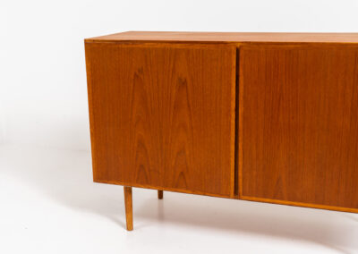 Midcentury Danish cabinet by Omann Jun (Denmark, 1960s). A sleek and convenient design with handle free doors and adjustable shelves on the inside. It’s made out of teak and features a beautiful warm woodgrain. In very good condition. Marked by maker on the back.