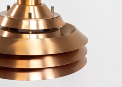 Copper plated Model 705 pendant light by Lyskaer (Denmark, 1960s). This space age beauty contains 4 aluminium shades with a copper colored exterior. The inside is lacquered in orange, which creates a beautiful and warm light dispersion. Newly rewired and in very good condition.
