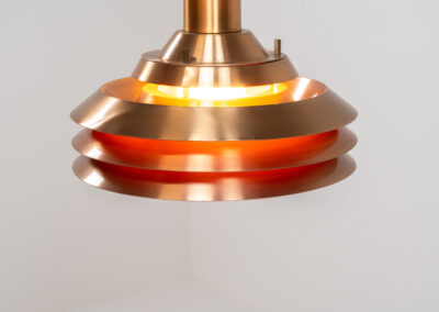 Copper plated Model 705 pendant light by Lyskaer (Denmark, 1960s). This space age beauty contains 4 aluminium shades with a copper colored exterior. The inside is lacquered in orange, which creates a beautiful and warm light dispersion. Newly rewired and in very good condition.