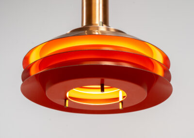 Copper plated Model 705 pendant light by Lyskaer (Denmark, 1960s). This space age beauty contains 4 aluminium shades with a copper colored exterior. The inside is lacquered in orange, which creates a beautiful and warm light dispersion. Newly rewired and in very good condition.