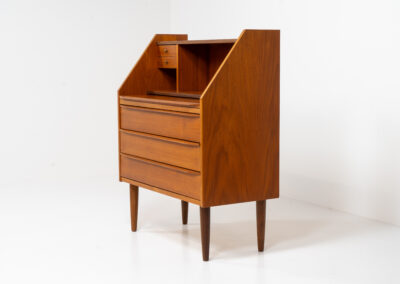 Danish secretary in teak, 1960s. A highly versatile piece featuring beautiful handles, a pull-out leaf and lots of storage space. A small and convenient piece that finds its way in any setting. In very good condition!