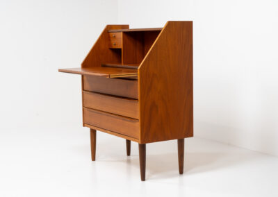 Danish secretary in teak, 1960s. A highly versatile piece featuring beautiful handles, a pull-out leaf and lots of storage space. A small and convenient piece that finds its way in any setting. In very good condition!