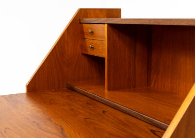 Danish secretary in teak, 1960s. A highly versatile piece featuring beautiful handles, a pull-out leaf and lots of storage space. A small and convenient piece that finds its way in any setting. In very good condition!