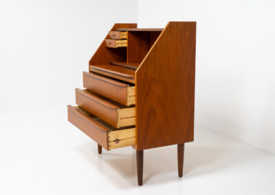 Danish secretary in teak, 1960s. A highly versatile piece featuring beautiful handles, a pull-out leaf and lots of storage space. A small and convenient piece that finds its way in any setting. In very good condition!
