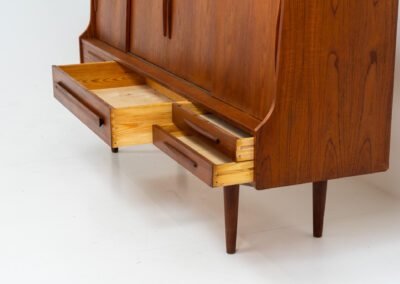 Beautiful sideboard by Tylvad Hansen in teak (Denmark, 1960s). It contains four sliding doors, four small drawers and one big drawer. On the inside there are three adjustable shelves and a bar unit with four small drawers. Featuring a very nice warm woodgrain and beautiful handels. In very good condition.