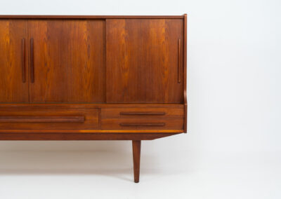 Beautiful sideboard by Tylvad Hansen in teak (Denmark, 1960s). It contains four sliding doors, four small drawers and one big drawer. On the inside there are three adjustable shelves and a bar unit with four small drawers. Featuring a very nice warm woodgrain and beautiful handels. In very good condition.