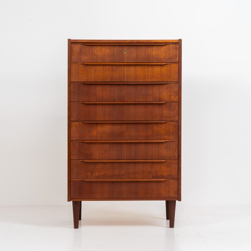 Danish tallboy chest of drawers in teak, 1960s. It contains 8 drawers with beautiful sculpted handles. The teak has a very nice and warm woodgrain. In good condition with normal traces of age and one repair spot.