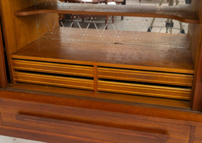 Beautiful sideboard by Tylvad Hansen in teak (Denmark, 1960s). It contains four sliding doors, four small drawers and one big drawer. On the inside there are three adjustable shelves and a bar unit with four small drawers. Featuring a very nice warm woodgrain and beautiful handels. In very good condition.