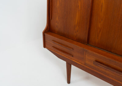 Beautiful sideboard by Tylvad Hansen in teak (Denmark, 1960s). It contains four sliding doors, four small drawers and one big drawer. On the inside there are three adjustable shelves and a bar unit with four small drawers. Featuring a very nice warm woodgrain and beautiful handels. In very good condition.