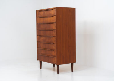 Danish tallboy chest of drawers in teak, 1960s. It contains 8 drawers with beautiful sculpted handles. The teak has a very nice and warm woodgrain. In good condition with normal traces of age and one repair spot.