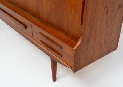 Beautiful sideboard by Tylvad Hansen in teak (Denmark, 1960s). It contains four sliding doors, four small drawers and one big drawer. On the inside there are three adjustable shelves and a bar unit with four small drawers. Featuring a very nice warm woodgrain and beautiful handels. In very good condition.