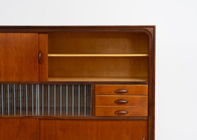 Beautiful and organic Danish highboard, 1960s. A very functional piece with lots of storage space and a wonderful organic shape. It contains four sliding doors, two glass sliding doors and some small drawers. In very good condition with some minor using traces.