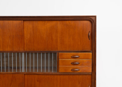 Beautiful and organic Danish highboard, 1960s. A very functional piece with lots of storage space and a wonderful organic shape. It contains four sliding doors, two glass sliding doors and some small drawers. In very good condition with some minor using traces.