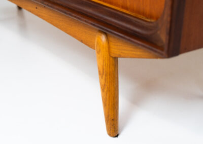 Beautiful and organic Danish highboard, 1960s. A very functional piece with lots of storage space and a wonderful organic shape. It contains four sliding doors, two glass sliding doors and some small drawers. In very good condition with some minor using traces.