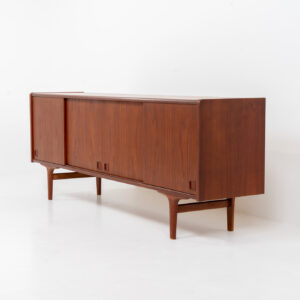 Danish sideboard in teak, 1960s. This two meter long low sideboard features four sleek sliding doors with some nice drawers and lots of storage space on the inside. It has a warm and vivid woodgrain. We don’t know who made this one, but it’s made with high quality. In very good condition with some minor signs of age and use.