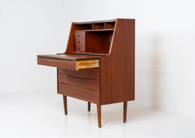 Teak secretary in the manner of Arne Vodder (Denmark, 1960s). A highly versatile piece featuring beautiful handles, a pull-out leaf and lots of storage space. A small and convenient piece that finds its way in any setting. In very good condition!