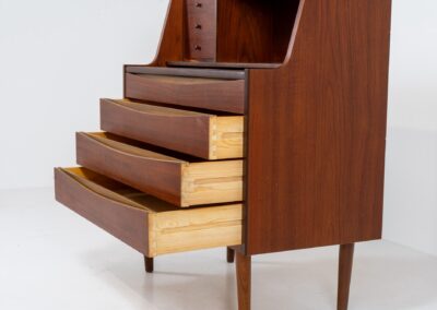 Teak secretary in the manner of Arne Vodder (Denmark, 1960s). A highly versatile piece featuring beautiful handles, a pull-out leaf and lots of storage space. A small and convenient piece that finds its way in any setting. In very good condition!