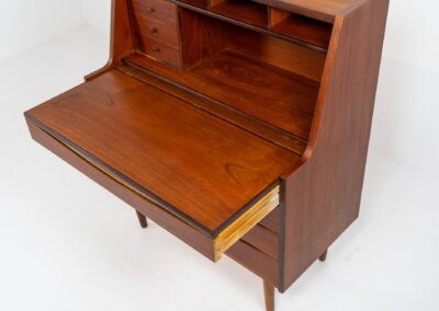 Teak secretary in the manner of Arne Vodder (Denmark, 1960s). A highly versatile piece featuring beautiful handles, a pull-out leaf and lots of storage space. A small and convenient piece that finds its way in any setting. In very good condition!