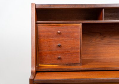 Teak secretary in the manner of Arne Vodder (Denmark, 1960s). A highly versatile piece featuring beautiful handles, a pull-out leaf and lots of storage space. A small and convenient piece that finds its way in any setting. In very good condition!