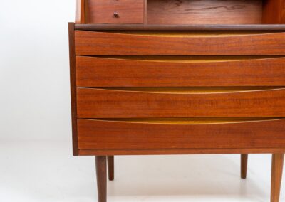 Teak secretary in the manner of Arne Vodder (Denmark, 1960s). A highly versatile piece featuring beautiful handles, a pull-out leaf and lots of storage space. A small and convenient piece that finds its way in any setting. In very good condition!