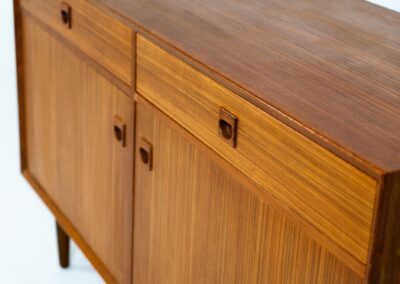 Teak sideboard by Brouer Møbel (Denmark, 1960s). A nice and convenient piece featuring two doors with adjustable shelves on the inside and two drawers. It has a beautiful warm woodgrain. In very good condition!