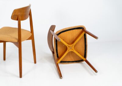 Remarkable set of 5 teak dining chairs by Harry Østergaard for Randers Møbelfabrik (Denmark, 1950s). Excellent craftsmanship! Featuring a beautifully curved backrest and a bentwood curved x-shaped base. They are fully restored and newly upholstered in an earthy orange/brown bouclé fabric. Ready for another lifetime!