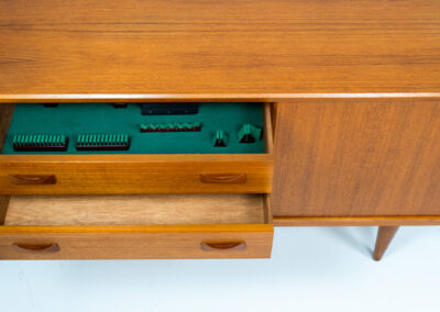 Teak sideboard by Clausen & Son (Denmark, 1960s). It features 2 sliding doors, adjustable shelves inside, 4 central drawers and nice sculptural handles. A high quality masterpiece in splendid condition! Marked by maker on the back.
