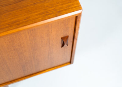 Teak sideboard by Clausen & Son (Denmark, 1960s). It features 2 sliding doors, adjustable shelves inside, 4 central drawers and nice sculptural handles. A high quality masterpiece in splendid condition! Marked by maker on the back.