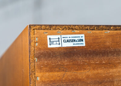 Teak sideboard by Clausen & Son (Denmark, 1960s). It features 2 sliding doors, adjustable shelves inside, 4 central drawers and nice sculptural handles. A high quality masterpiece in splendid condition! Marked by maker on the back.