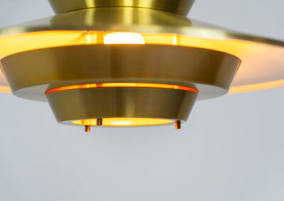 Brass colored pendant light (Denmark, 1970s). We don’t know who made this one but it’s definitely a beautiful piece! Parts of the inside are lacquered in orange which gives a nice effect when turned on. In very good condition with some minor scratches.