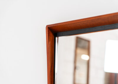 Elegant Mid-Century wall mirror (Denmark, 1960s). Featuring a beautiful organic frame in solid teak, a black trim and a faceted glass mirror. The combination of the curved frame and the black trim makes this mirror a pleasure for the eyes! In very good condition.