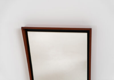 Elegant Mid-Century wall mirror (Denmark, 1960s). Featuring a beautiful organic frame in solid teak, a black trim and a faceted glass mirror. The combination of the curved frame and the black trim makes this mirror a pleasure for the eyes! In very good condition.