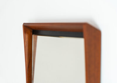 Elegant Mid-Century wall mirror (Denmark, 1960s). Featuring a beautiful organic frame in solid teak, a black trim and a faceted glass mirror. The combination of the curved frame and the black trim makes this mirror a pleasure for the eyes! In very good condition.