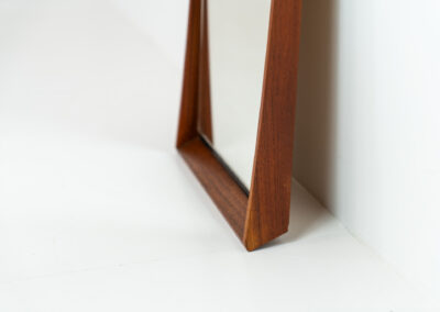 Elegant Mid-Century wall mirror (Denmark, 1960s). Featuring a beautiful organic frame in solid teak, a black trim and a faceted glass mirror. The combination of the curved frame and the black trim makes this mirror a pleasure for the eyes! In very good condition.