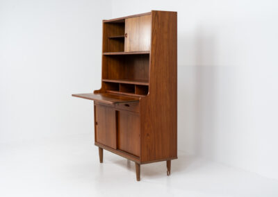 Teak secretary/bookcase by Harald Nielsen (Denmark, 1960s). A nicely designed and multifunctional piece containing four sliding doors, two drawers, a convenient pull-out leaf and some open storage space. Featuring nice handles and a warm natural wood grain. It is in splendid condition and the original key is included.